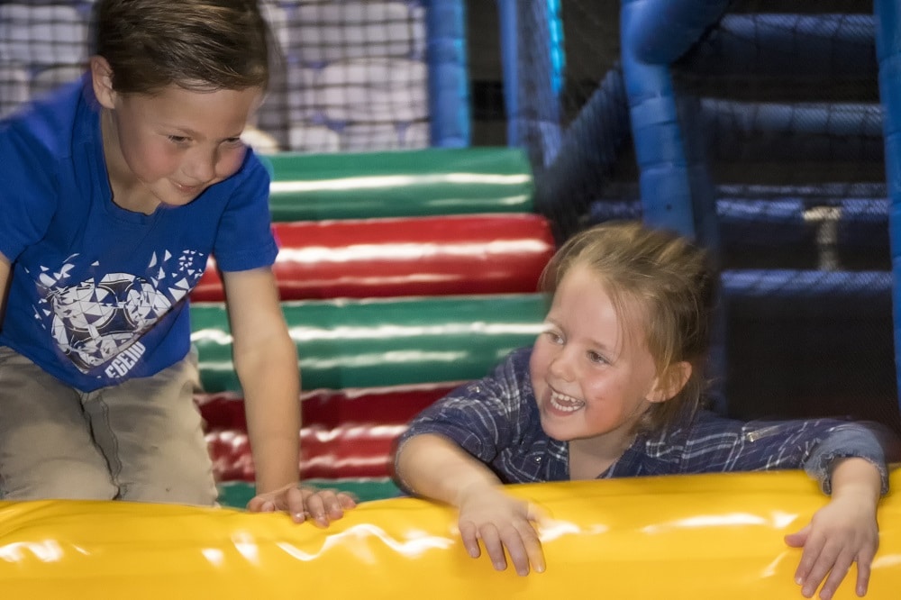 Kinderen hebben plezier op helling van schuim in het Klimkasteel