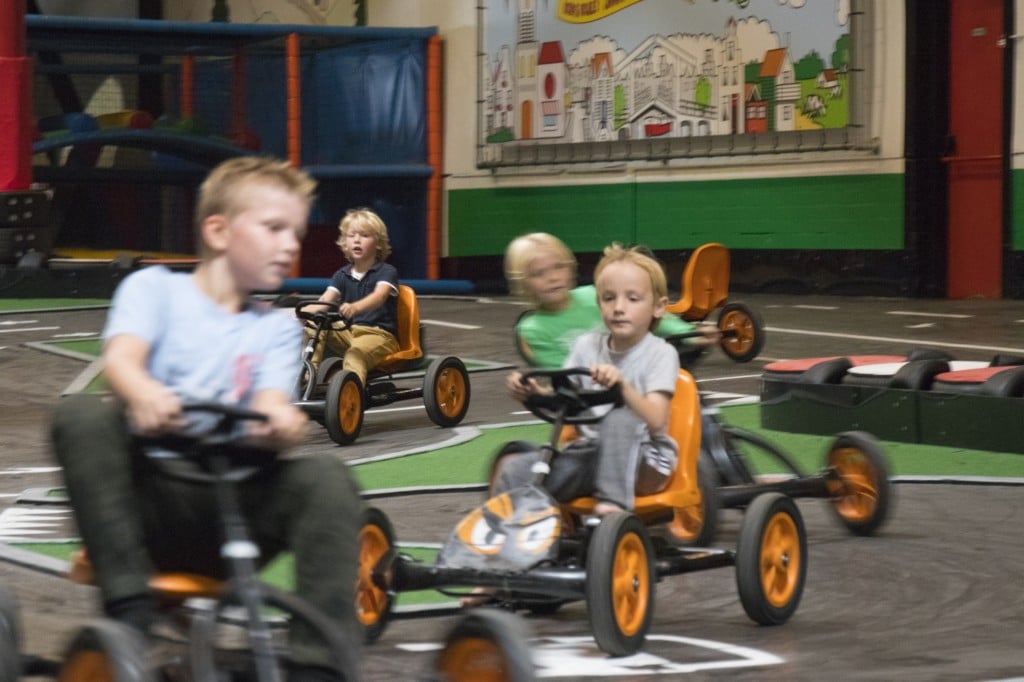 Jongens rijden door de bocht op skelters van de skelterbaan van Jimmy's Speelparadijs