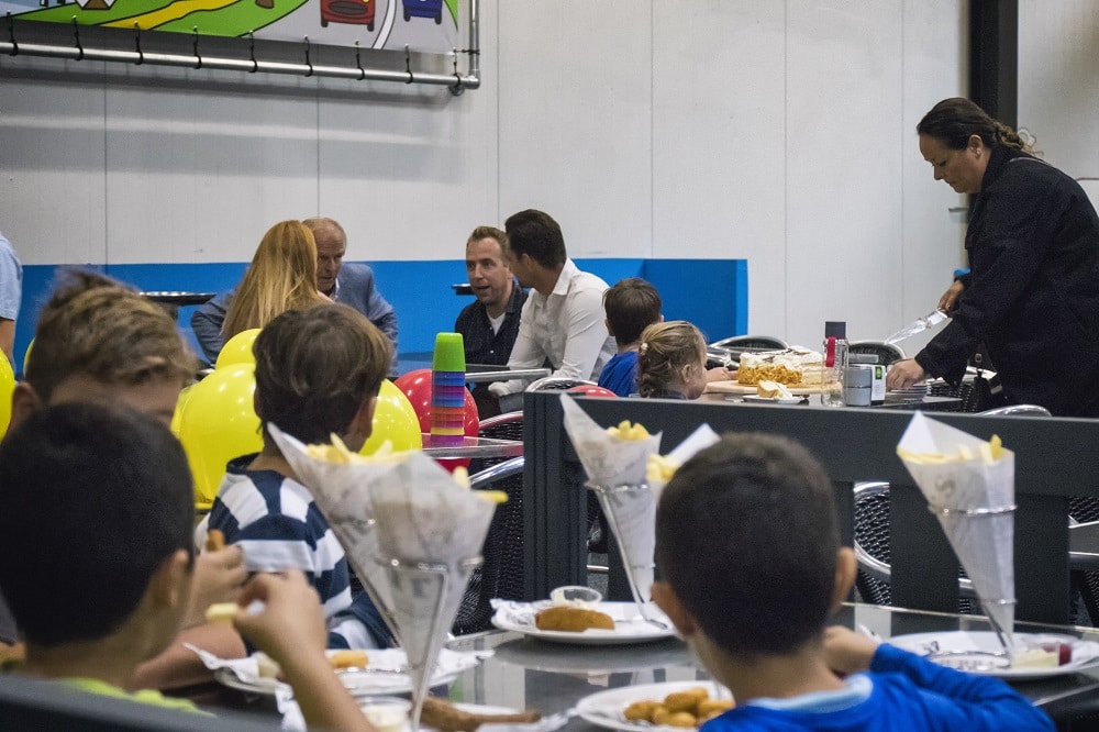 ouders en kinderen op het terras van Jimmy's Speelparadijs hebben plezier