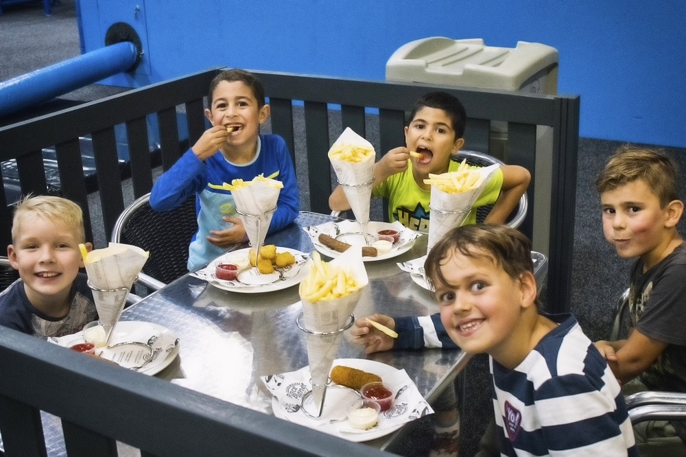 kinderen eten patat friet en snacks op het terras tijdens feestje