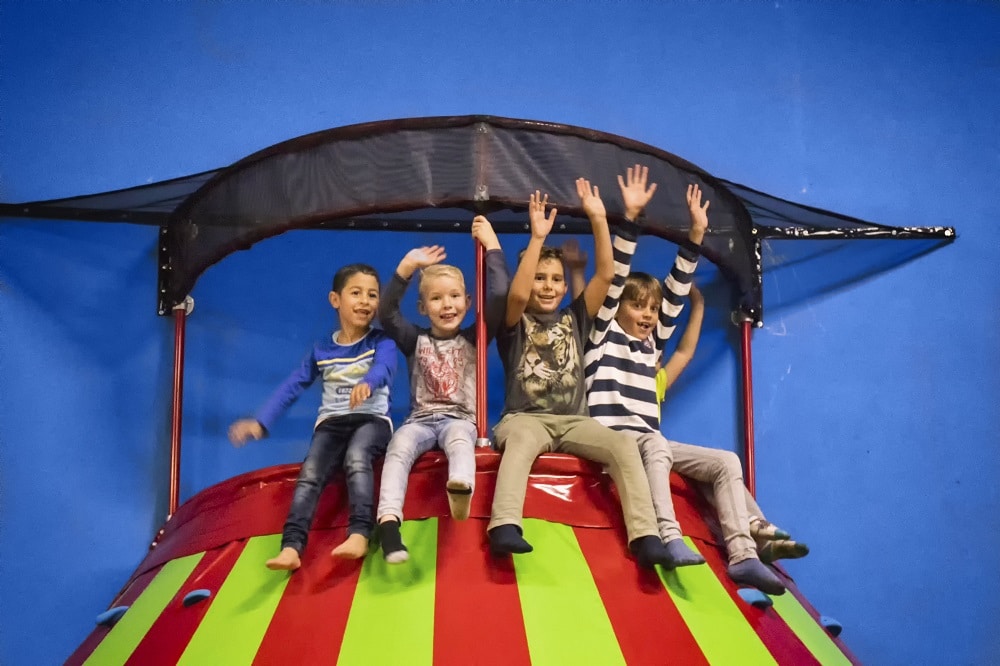 Kinderen zittend bovenop de klautertoren die plezier hebben.