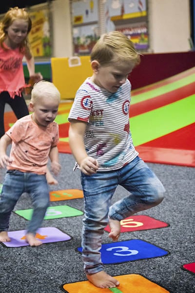 Kinderen hinkelen naast de klautertoren in Jimmy's speelparadijs