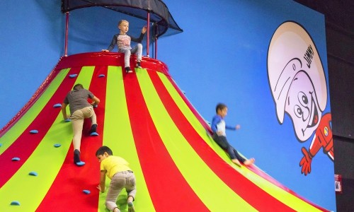 Klautertoren van Jimmy's Speelparadijs met spelende kinderen die omhoog klimmen en naar beneden glijden.